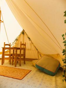 阿什伯恩Hope Cottage Bell Tent Retreat的帐篷配有椅子和桌子