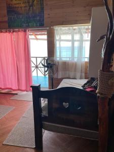布兰卡滩Princesa del Mar的卧室配有一张床铺,位于一间设有粉红色窗帘的房间