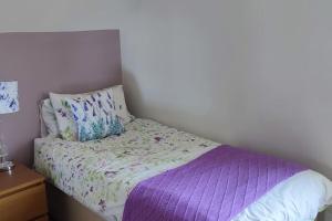 红堡Tullyally's View的一张带紫色棉被和枕头的小床