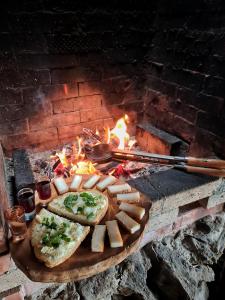 肯佩尼Cabana Dor de Apuseni的壁炉前的木板,包括面包和奶酪