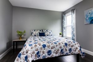 尼亚加拉瀑布Quaint 1 Bedroom Apartment Sleeps 2-3, Near Niagara Falls的一间卧室配有一张带蓝色和白色棉被的床