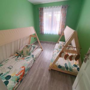 马里尼亚讷Joli haut de villa 3 chambres climatisé avec jacuzzi的带两张双层床的绿色墙壁客房