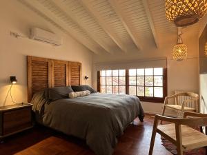 门多萨Oeste suites的卧室配有床、椅子和窗户。