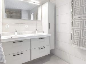 斯托滕Holiday home Sälen的白色的浴室设有水槽和镜子