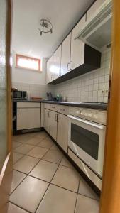 珀丽Apartment Bärenfelsblick的厨房配有白色橱柜和炉灶。