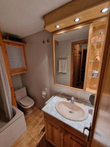 陶尔Apartamento acogedor con vistas的一间带水槽、卫生间和镜子的浴室