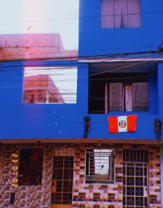 利马Inti Hostel Airport的前面有旗帜的蓝色建筑