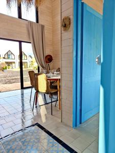 梅尔诺Lulu Holiday Resort的配有桌椅和蓝色门的房间
