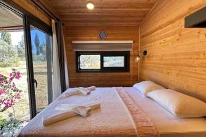 卡斯Tiny House Patara的木制客房内的一张大床,设有窗户
