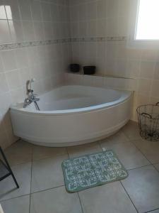瓦讷Schumann Jardin Vannes的浴室的白色浴缸,浴室的体重秤在地板上