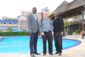 鲁亨盖里Fatima Hotel的三个男人站在游泳池旁