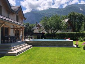 勒布罗伊斯Chalet Barbara with swimming pool in the heart of Oisans的一个带游泳池和房子的后院