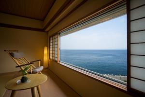 洲本市太阳广场淡路国际酒店的客房设有带椅子的窗户,享有海景。