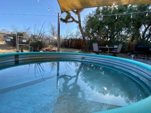 约书亚树Float Pool, Hot Tub, Sauna, Firepit, BBQ, Telescope, Views, EV Chg,的水中的人反射的游泳池