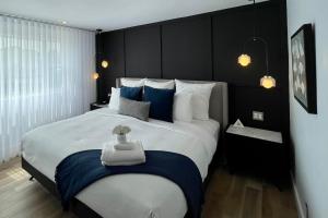 拜圣保罗Domaine Belle Plage的一间卧室配有一张带蓝白色枕头的大床