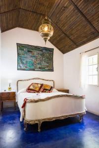 Real de San CarlosCozy Country House in Colonia - Uruguay的一间卧室配有一张床和一个吊灯