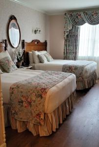 柏斯海滩Boardwalk Plaza Hotel的酒店客房,设有两张床和镜子