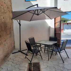 底拉斯卡拉Hotel Tlaxcala的露台的遮阳伞下的桌椅