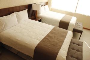 底拉斯卡拉Hotel Tlaxcala的酒店客房设有两张床和窗户。