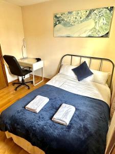 伦敦London Mackenzie Apartment的一间卧室配有一张带桌子和椅子的床