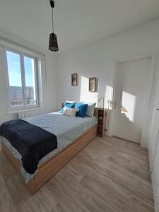 费康Le Rayon Vert vue mer的一间卧室配有一张带蓝色枕头的大床