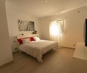大加那利岛拉斯帕尔马斯Finca Artiles的一间卧室配有一张带红色枕头的床和一扇窗户