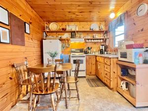MiddletonStargazers Cove Cottages Blue Heron的厨房设有木墙和桌椅