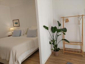米尔芳提斯城Estúdio Lagoa Azul的一间卧室配有一张床和盆栽植物