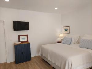 米尔芳提斯城Estúdio Lagoa Azul的一间卧室配有两张床和一台平面电视
