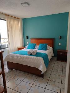 巴尼奥斯Hostal CañaLimeña的一间卧室配有一张带蓝色墙壁的大床