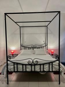 RufisqueThe coolest room的一间卧室配有一张黑色天蓬床和两个红色蜡烛