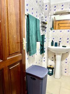 RufisqueThe coolest room的浴室提供绿色毛巾、水槽和垃圾桶