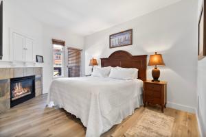 帕克城Sundial Lodge 2 Bedroom by Canyons Village Rentals的一间白色卧室,配有一张床和一个壁炉
