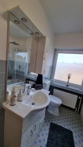 博霍尔特Bocholt Apartment Ferienwohnung的一间带水槽、卫生间和镜子的浴室