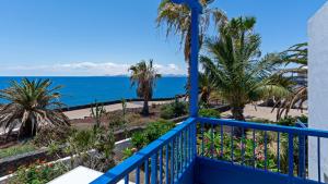 普拉亚布兰卡Villa Vista Mar的拥有棕榈树和海洋的蓝色阳台