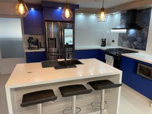 卢基约Luquillo Mar Paradise的厨房配有白色的柜台和蓝色的橱柜。