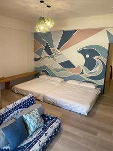 台东浪居民宿的一间卧室配有两张床、一张沙发和一个壁画