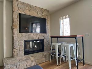 布勒山Frostwood的客厅设有石制壁炉和平面电视。