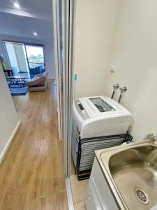 卡尔斯菲利普岛塔楼公寓的洗衣房配有洗衣机和水槽
