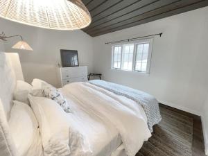 Cottage Retreat - Historic Cottage Home w Home Gym的白色的卧室设有床和窗户