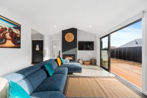 陶波CatchN'Relax Taupo的客厅设有蓝色的沙发和壁炉