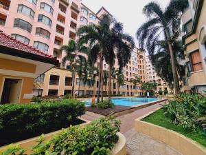 马尼拉Legarse Staycation at Montecito Residential Resort的酒店庭院种有棕榈树,设有游泳池