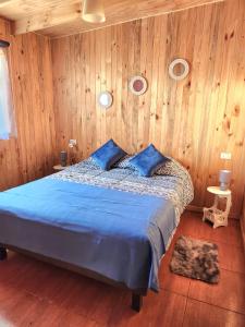 奥索尔诺Cabañas Entre copihues的一间卧室配有蓝色的床和木墙