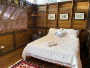 温泉村Kebun Lisdtari farmstay的卧室配有白色的床和木墙