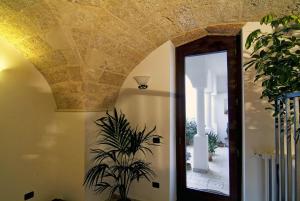 帕拉比塔B&b Altrov'è的走廊上设有天花板、镜子和植物