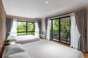 曼谷萨格布小巢酒店的一间卧室设有两张床和大窗户