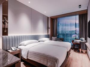香港Dorsett Kai Tak的一间设有大床和窗户的酒店客房