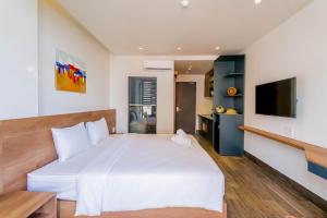 岘港Lantana House Boutique Da Nang by Haviland的卧室配有一张白色大床和一台平面电视。