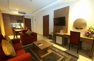梭罗Lorin Dwangsa Solo Hotel的客厅配有红色的沙发和桌子