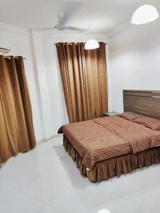 塞拉莱رحاب السعاده rehab alsaadah apartment的一间带床的卧室,位于带窗帘的房间